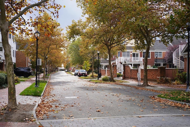 view of street with street lighting, a residential view, curbs, and sidewalks