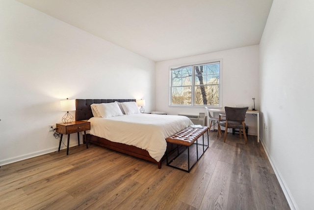 bedroom with baseboards and wood finished floors