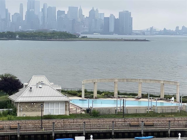 view of water feature with a view of city and fence