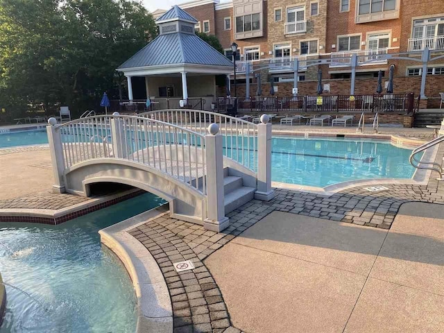 community pool with a patio area and fence