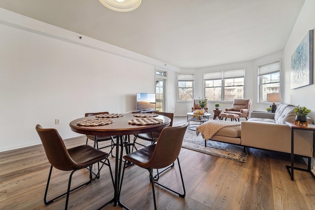 dining room with plenty of natural light, baseboards, and wood finished floors