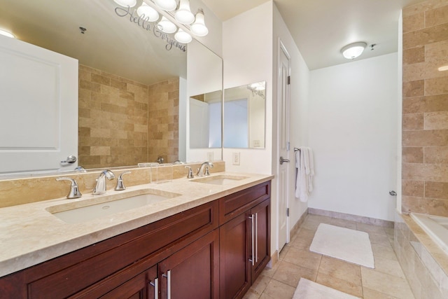 bathroom with double vanity, tile patterned flooring, a sink, and baseboards