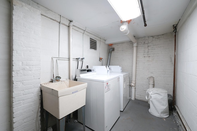 laundry area with independent washer and dryer and sink