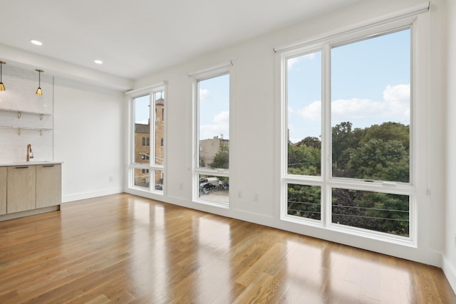 unfurnished living room with light wood-type flooring and sink