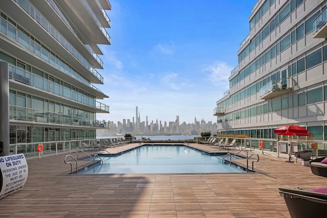 community pool with a city view and a patio area