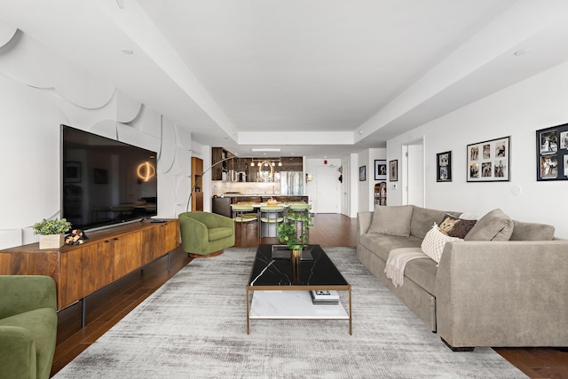 living area featuring a raised ceiling and light wood finished floors