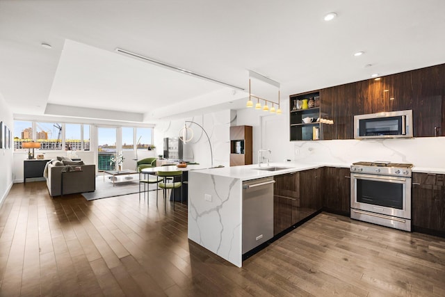 kitchen featuring appliances with stainless steel finishes, modern cabinets, open shelves, a sink, and open floor plan