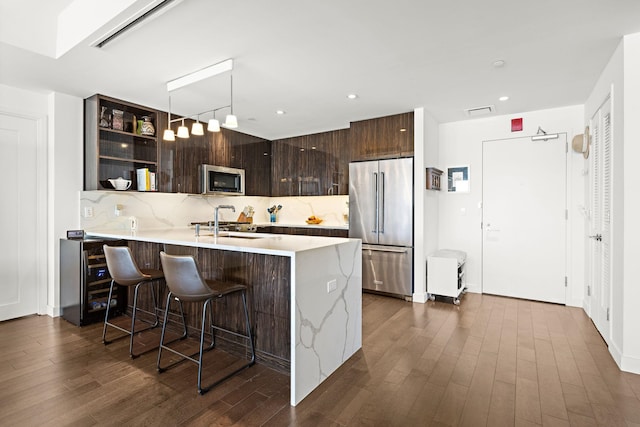 kitchen with dark brown cabinets, light countertops, stainless steel appliances, backsplash, and modern cabinets