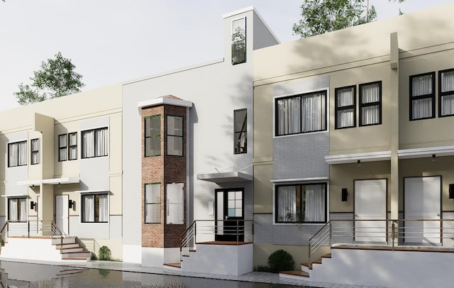 view of front facade featuring brick siding and stucco siding