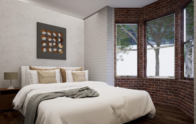 bedroom with brick wall and wood finished floors