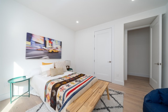 bedroom with recessed lighting, baseboards, and wood finished floors