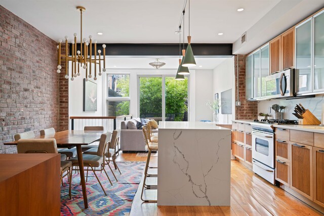 275 5th St Unit 1, Jersey City, NJ 07302 - kitchen featuring gas range gas stove, stainless steel microwave, light wood finished floors, a chandelier, and glass insert cabinets