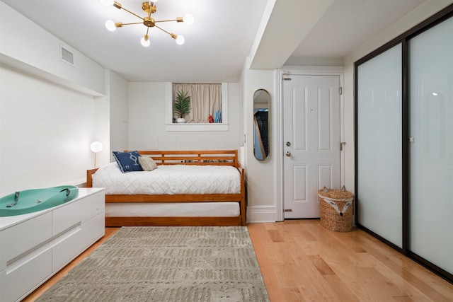275 5th St Unit 1, Jersey City, NJ 07302 - bedroom featuring light wood-style floors and a chandelier