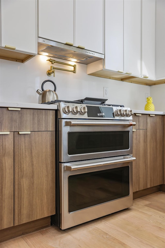 44 Bleecker St Unit 2, Jersey City, NJ 07307 - kitchen with double oven range, white cabinetry, light countertops, and modern cabinets