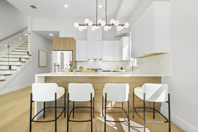 44 Bleecker St Unit 2, Jersey City, NJ 07307 - kitchen featuring high quality fridge, a peninsula, baseboards, and light wood-type flooring