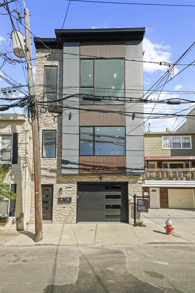 44 Bleecker St Unit 2, Jersey City, NJ 07307 - view of building exterior with concrete driveway and a garage