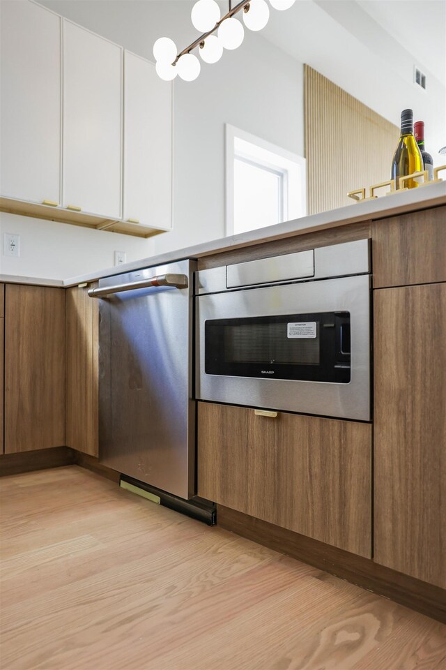 44 Bleecker St Unit 2, Jersey City, NJ 07307 - kitchen featuring dishwasher, white cabinetry, light wood finished floors, and brown cabinetry