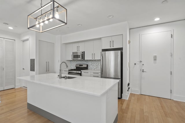 kitchen featuring pendant lighting, sink, an island with sink, and appliances with stainless steel finishes