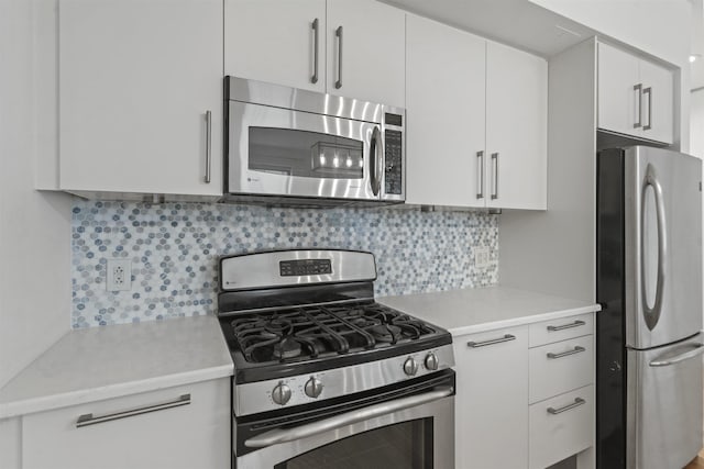 kitchen with white cabinetry, backsplash, and stainless steel appliances