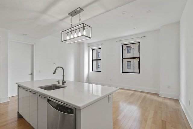 kitchen with sink, white cabinetry, hanging light fixtures, dishwasher, and a kitchen island with sink