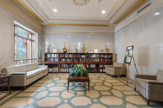 living area with ornamental molding and a raised ceiling