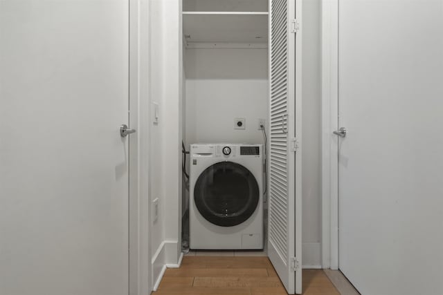 clothes washing area featuring washer / dryer and light hardwood / wood-style floors