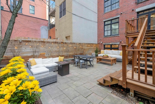 view of patio with an outdoor living space with a fire pit