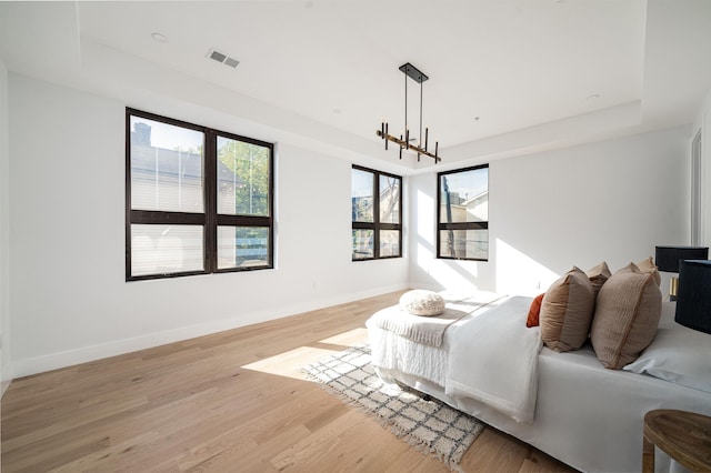 bedroom featuring light wood-type flooring and a notable chandelier