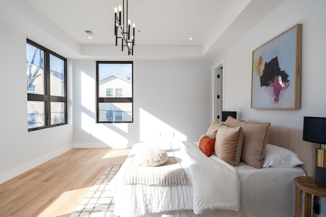 bedroom featuring a chandelier and light hardwood / wood-style floors