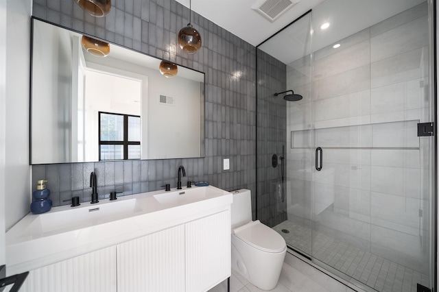 bathroom with tasteful backsplash, vanity, tile walls, toilet, and a shower with shower door