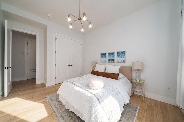 bedroom with a chandelier, light hardwood / wood-style floors, and a closet