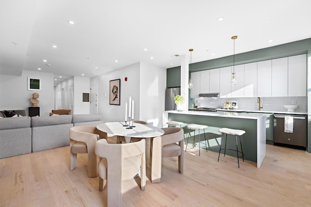 dining area with light hardwood / wood-style flooring and sink