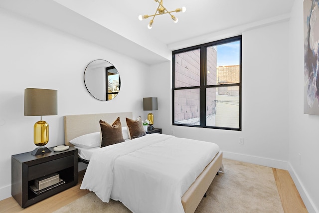 bedroom featuring light hardwood / wood-style floors and an inviting chandelier