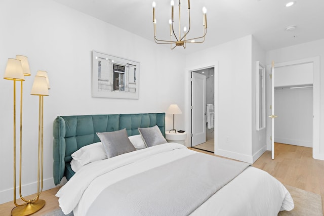 bedroom with light hardwood / wood-style floors, a notable chandelier, and ensuite bathroom