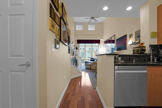 corridor with sink, hardwood / wood-style floors, and a high ceiling