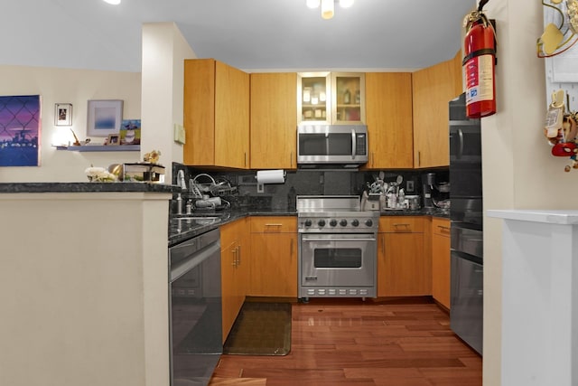 kitchen featuring sink, decorative backsplash, dark wood-type flooring, and stainless steel appliances