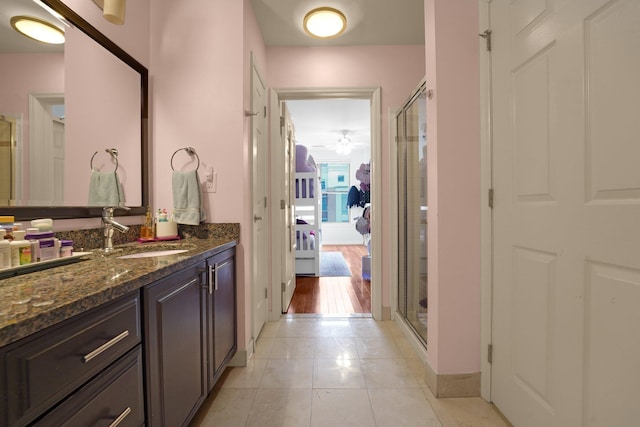 bathroom featuring vanity, a shower with shower door, and tile patterned floors