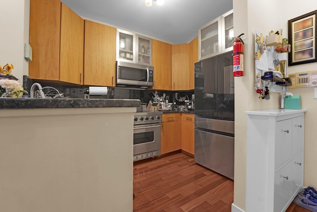 kitchen featuring appliances with stainless steel finishes, dark hardwood / wood-style flooring, and decorative backsplash