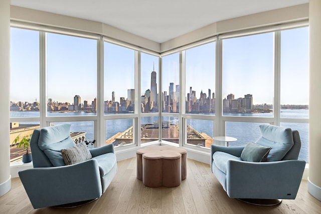 sunroom / solarium with a healthy amount of sunlight, a view of city, and a water view