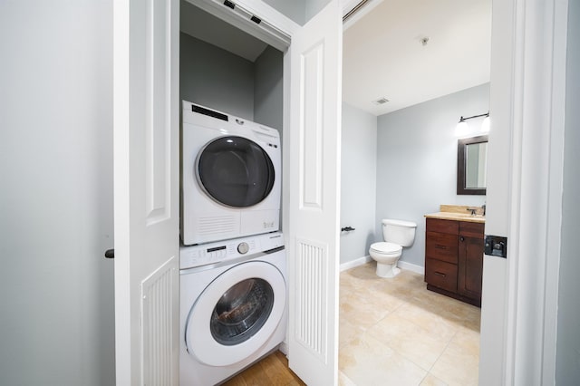 100 Paterson Plank Rd Unit 229, Jersey City, NJ 07030 - clothes washing area featuring laundry area, light tile patterned floors, a sink, stacked washer and clothes dryer, and baseboards