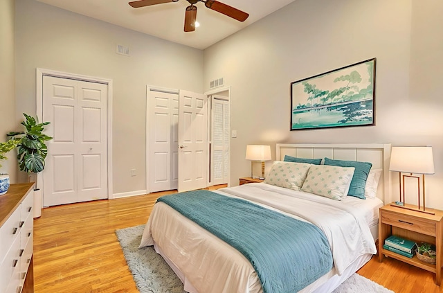 187 Wayne St Unit 208C, Jersey City, NJ 07302 - bedroom with multiple closets, light wood finished floors, a ceiling fan, and a high ceiling
