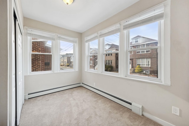 unfurnished sunroom featuring a baseboard heating unit