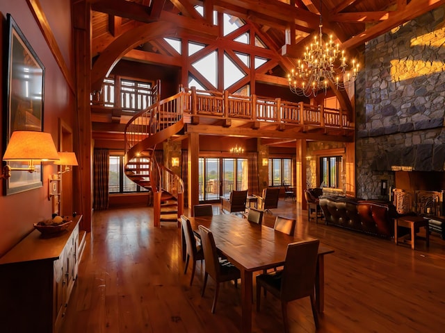 dining space with hardwood / wood-style flooring, high vaulted ceiling, and a notable chandelier