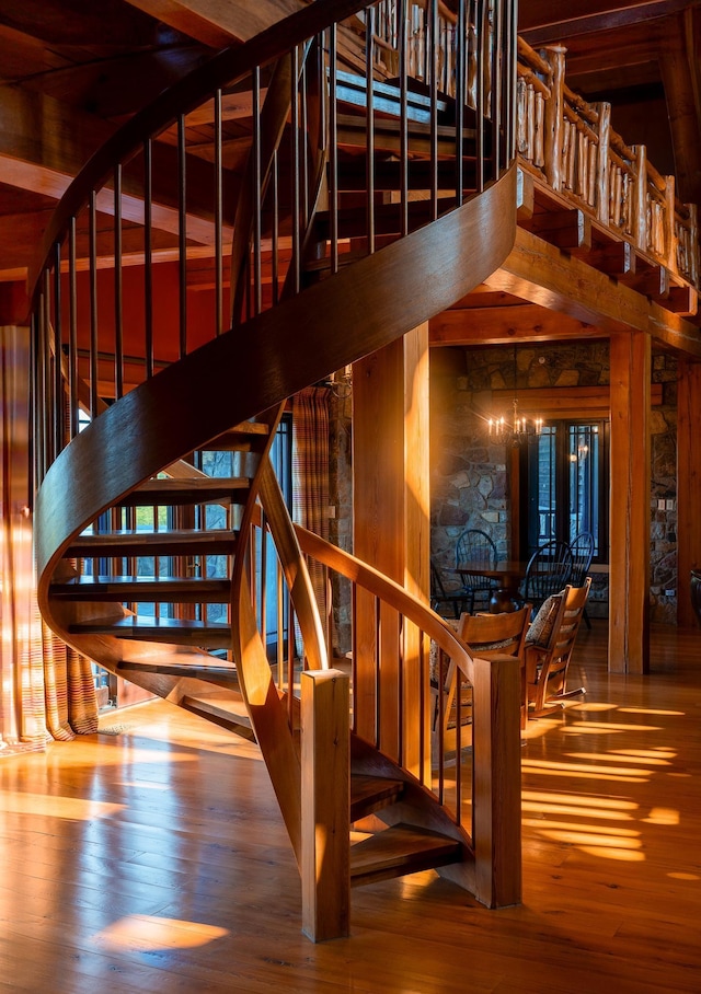 stairway featuring a towering ceiling and hardwood / wood-style floors