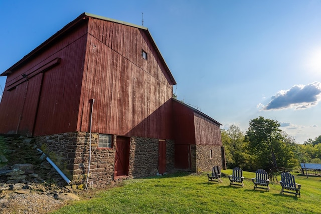 rear view of house featuring an outbuilding and a yard