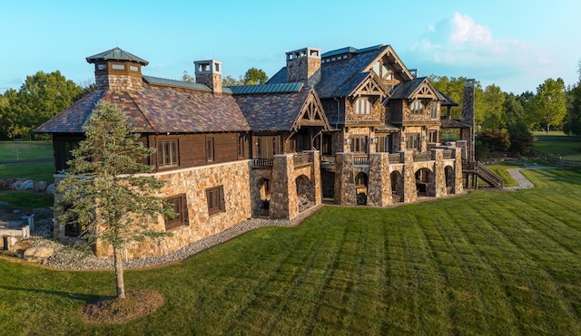 rear view of house featuring a lawn