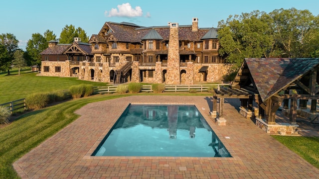 view of pool featuring a lawn and a patio area