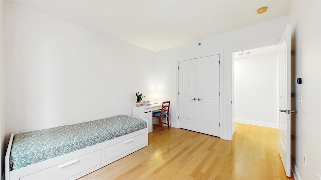 10 Regent St Unit 201, Jersey City, NJ 07302 - bedroom with light wood-style floors, a closet, a desk, and baseboards