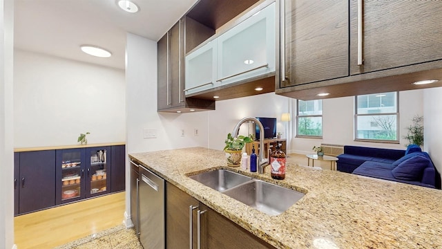 10 Regent St Unit 201, Jersey City, NJ 07302 - kitchen with a sink, stainless steel dishwasher, glass insert cabinets, and light stone counters
