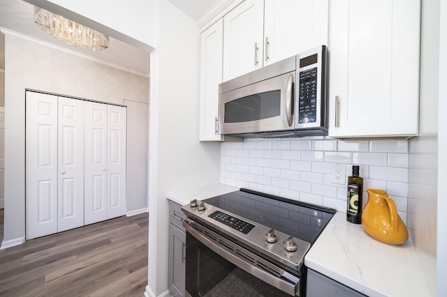 20 2nd St Unit 2503, Jersey City, NJ 07302 - kitchen with stainless steel appliances, crown molding, light stone countertops, wood finished floors, and decorative backsplash